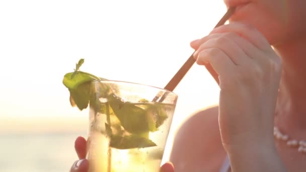 Primer plano de una mujer disfrutando de un cóctel mojito en la playa — Vídeo de stock