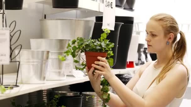 Young blond woman looking at vases and plants in a gardening shop — Stock Video