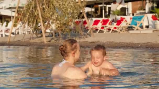 Moeder en haar jonge kind Baden in het zeewater — Stockvideo