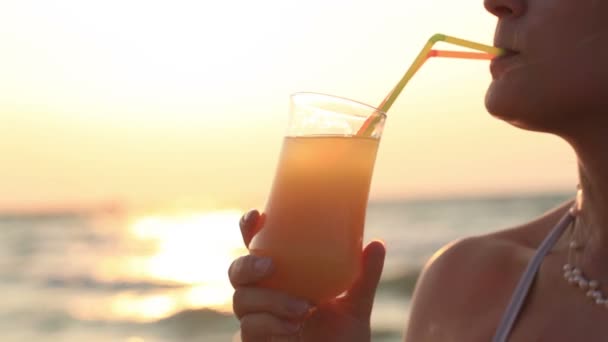 Жінка проковтнула холодний освіжаючий коктейль на заході сонця — стокове відео