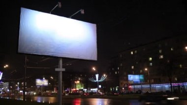 zaman sukut kentsel sahne ile yan tarafındaki bir sokak arabalar hareket ile aydınlatılmış bir boş billboard