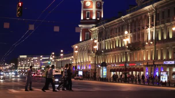 Ulica Newski Prospekt w nocy: ludzie przez jezdnię w pobliżu oświetlony budynek starego. St. petersburg, Federacja Rosyjska — Wideo stockowe