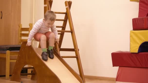 Young boy playing on an indoor playground — Stock Video