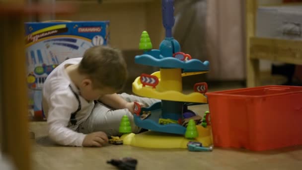 Little boy playing with a plastic parking garage — Stock Video