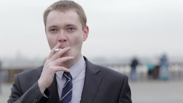 Бизнесмен курит сигарету — стоковое видео