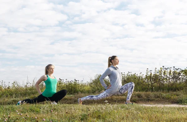 Two young girls exercising outdoors — Stock Photo, Image