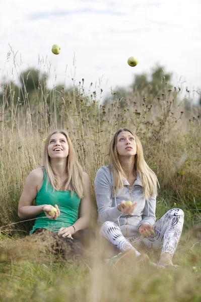 Two playful girls juggling outdoors — Stock Photo, Image