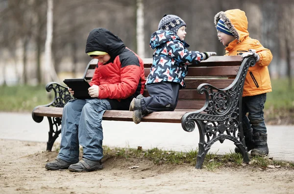 Three young boys playing in a park — Stock Photo, Image
