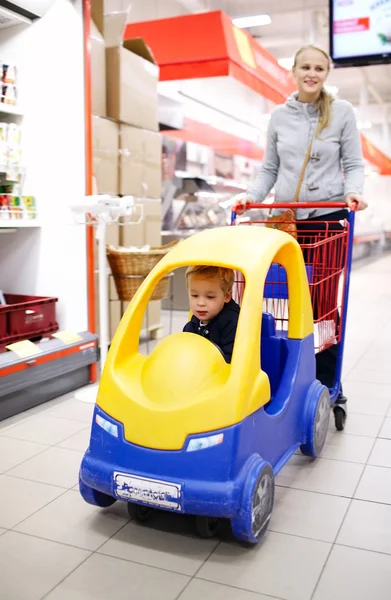 Criança com mãe no supermercado — Fotografia de Stock