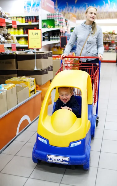Barn og mor i supermarked - Stock-foto