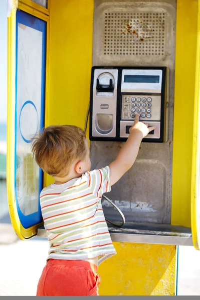 Young boy with phone in a booth — Stock Photo, Image