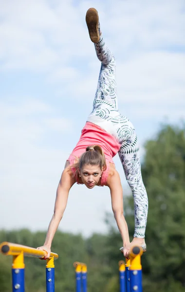 Agile joven gimnasta equilibrio en barras transversales — Foto de Stock