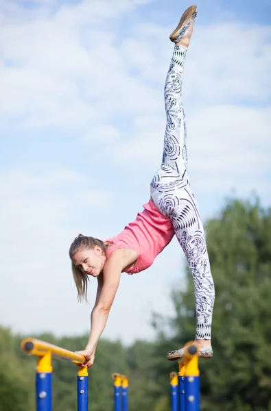 Agile joven gimnasta equilibrio en barras transversales —  Fotos de Stock