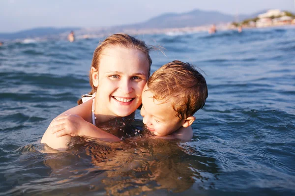 Felice madre insegnare il suo giovane figlio a nuotare — Foto Stock