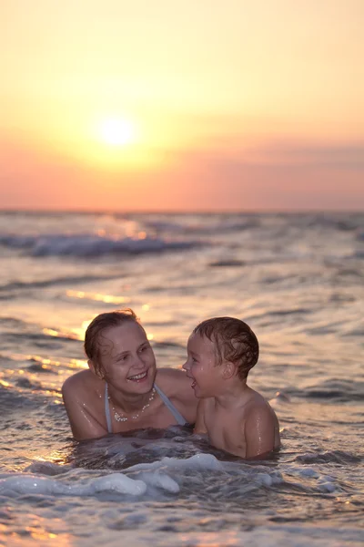 Madre godendo di una nuotata serale con suo figlio — Foto Stock