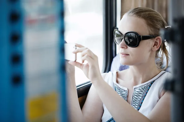 Woman taking pictures at her mobile on a bus — Stock Photo, Image
