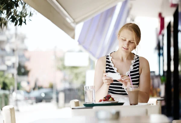 Mulher atraente tirar foto de uma pastelaria em seu celular — Fotografia de Stock