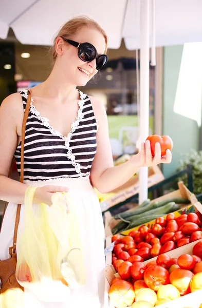 Νεαρή γυναίκα ψώνια για φρέσκιες ντομάτες — Φωτογραφία Αρχείου