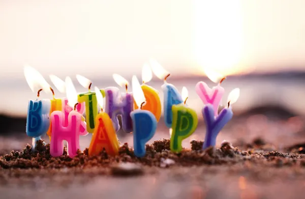 Candele di compleanno che bruciano su una spiaggia — Foto Stock