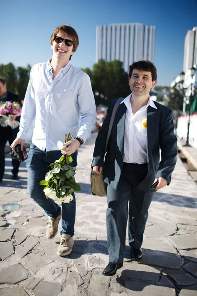 Двое улыбающихся мужчин идут по улице — стоковое фото