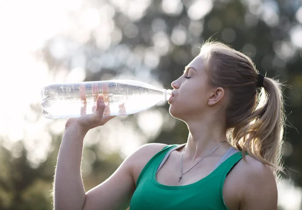 Junge Frau trinkt Wasser nach Fitness — Stockfoto
