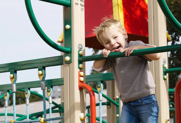 Ragazzo su attrezzature da parco giochi. — Foto Stock