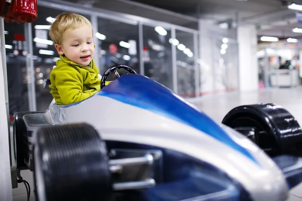 Little boy driving a racing car — Stock Photo, Image