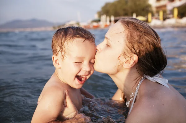 Мать целует своего маленького ребенка — стоковое фото