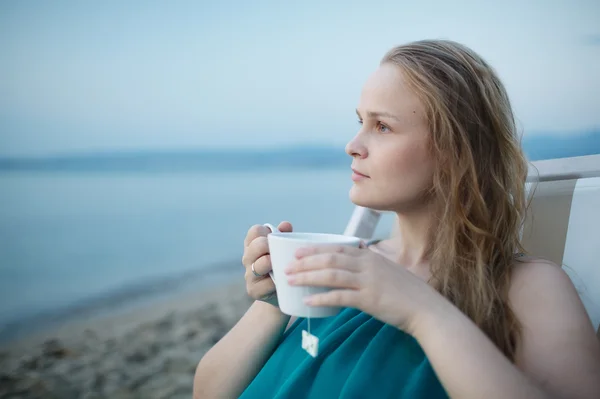 Žena se těší šálek čaje u moře — Stock fotografie