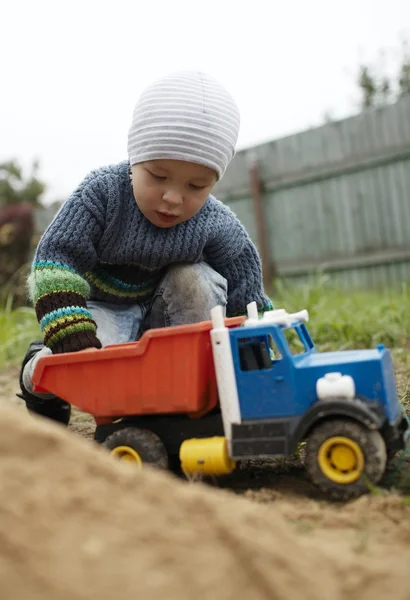 Мальчик играет с игрушечным грузовиком на улице — стоковое фото