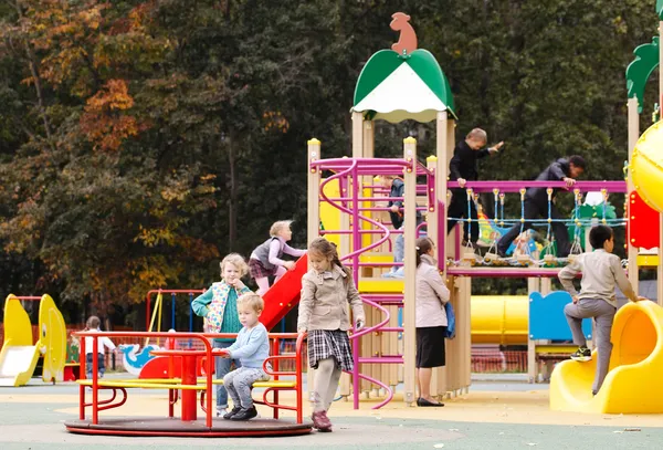 Crianças brincando em um playground ao ar livre — Fotografia de Stock