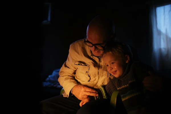 Großvater umarmt seinen Enkel am Kamin — Stockfoto
