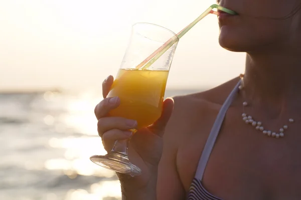 Woman sipping a refreshing cocktail at sunset — Stock Photo, Image