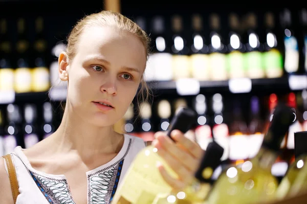 Mujer comprando alcohol en una tienda de botellas — Foto de Stock