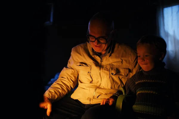 Grandfather and grandson near fire at home. — Stock Photo, Image