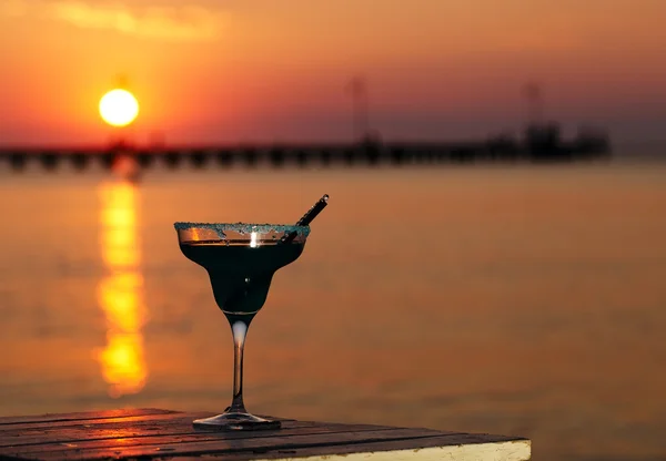 Tropical cocktail overlooking a sunset ocean — Stock Photo, Image