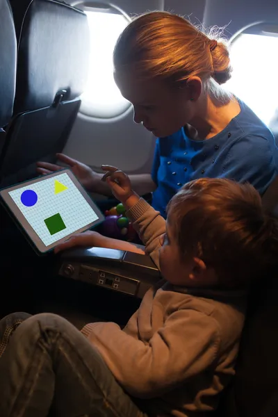 Молодые мать и сын путешествуют на самолете — стоковое фото