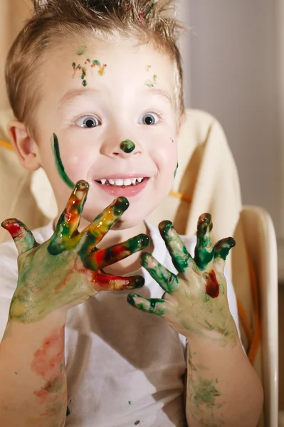 Schattige opgewonden jongen met handen vol van vinger verf — Stockfoto