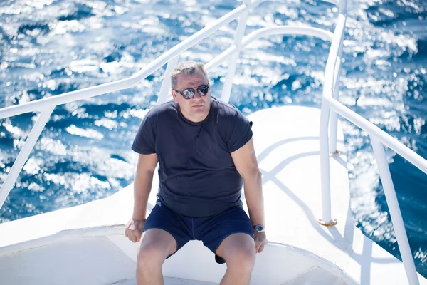 Homem sentado na proa de um barco — Fotografia de Stock