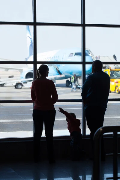 Ung familj titta på flygplan på en flygplats — Stockfoto