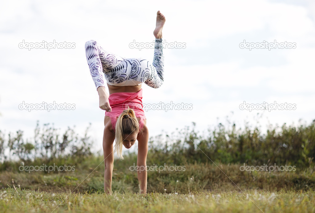 Agile young woman doing a handstand