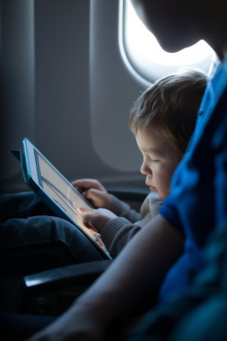 küçük çocuk bir tablet bir uçak ile oynama