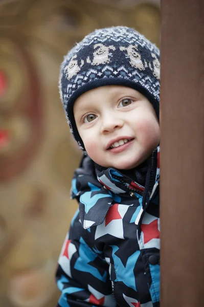 Carino piccolo ragazzo peering intorno a un porta — Foto Stock