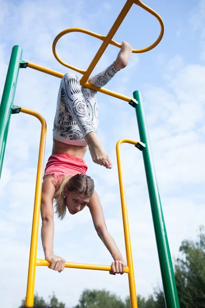 Hermosa joven gimnasta haciendo ejercicio al aire libre — Foto de Stock