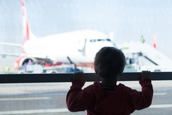 Маленький мальчик смотрит самолеты в аэропорту — стоковое фото