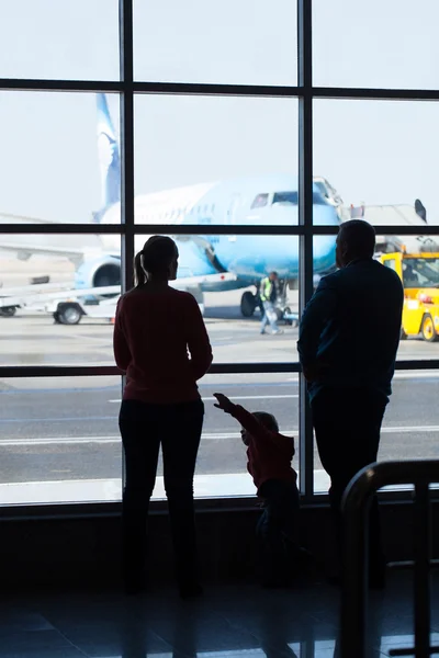 Joven familia viendo aviones en un aeropuerto — Foto de Stock