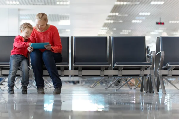 Jovem mãe e filho em um terminal de aeroporto — Fotografia de Stock