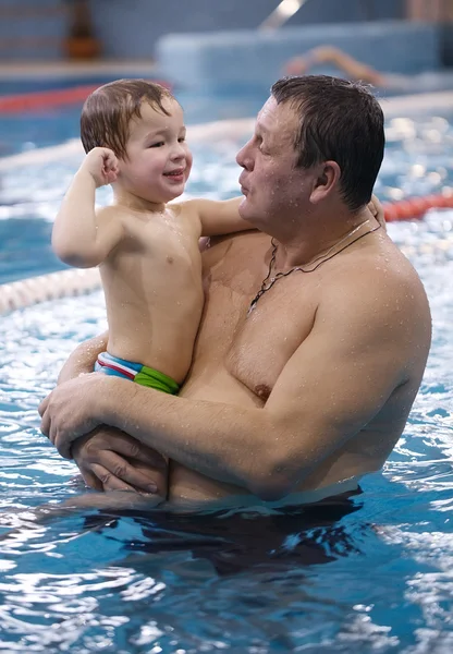 Abuelo jugando con su nieto en una piscina — Foto de Stock