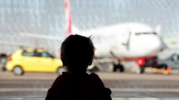 Kleiner Junge beobachtet Flugzeuge am Flughafen — Stockvideo