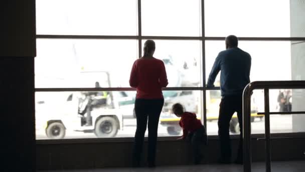 Jonge gezin kijken vliegtuigen op een luchthaven — Stockvideo